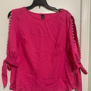 Pink shirt with pearl embellishment on sleeves.